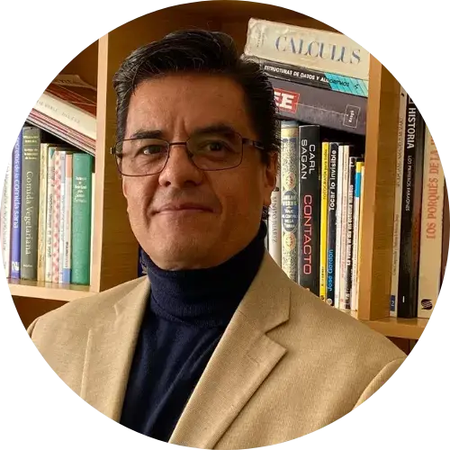 Luis Antonio Nieto, with tan blazer, black turtleneck in front of bookcase.
