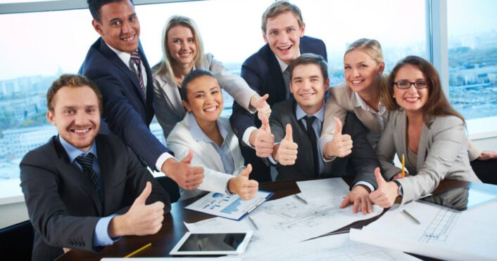Advanced English Class Group Session Group of professionals in a business setting giving thumbs up, symbolizing success and confidence gained through advanced English classes